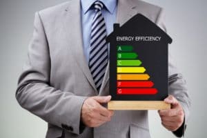 Homme tenant les normes relatives à l'efficacité énergétique d'une maison après isolation phonique et thermique, principes et normes de l'isolation acoustique
