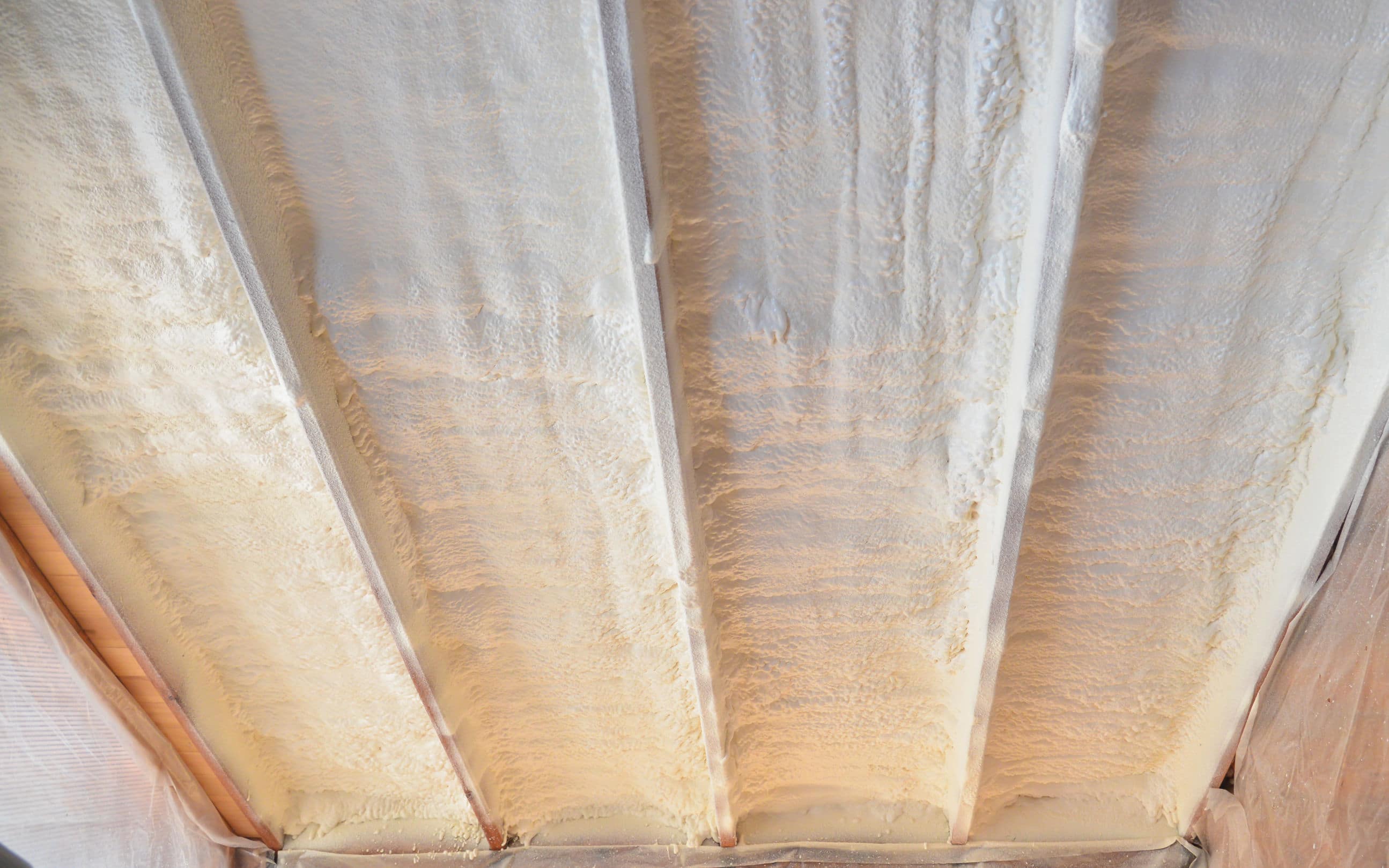 Rêvetement d'une sous toiture par un isolant phonique en mousse polyuréthane par pulvérisation pour l’isolation phonique de maison, isolation rampants
